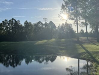Sunrise over a lake on the second hole at Orange Lake Reserve Course in Kissimmee, Florida