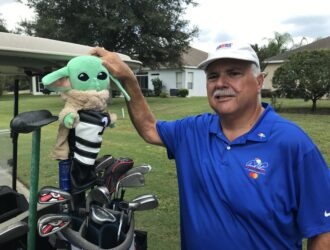 Happy golfer displaying his Grogu head cover.