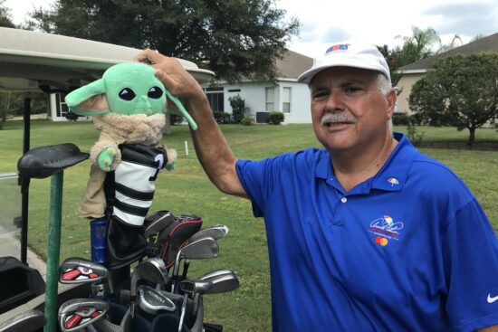 Happy golfer displaying his Grogu head cover.